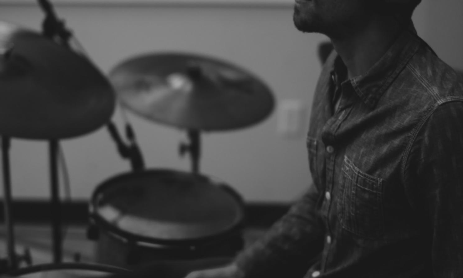 Estudiante componiendo música en estudio digital con instrumentos y software profesional